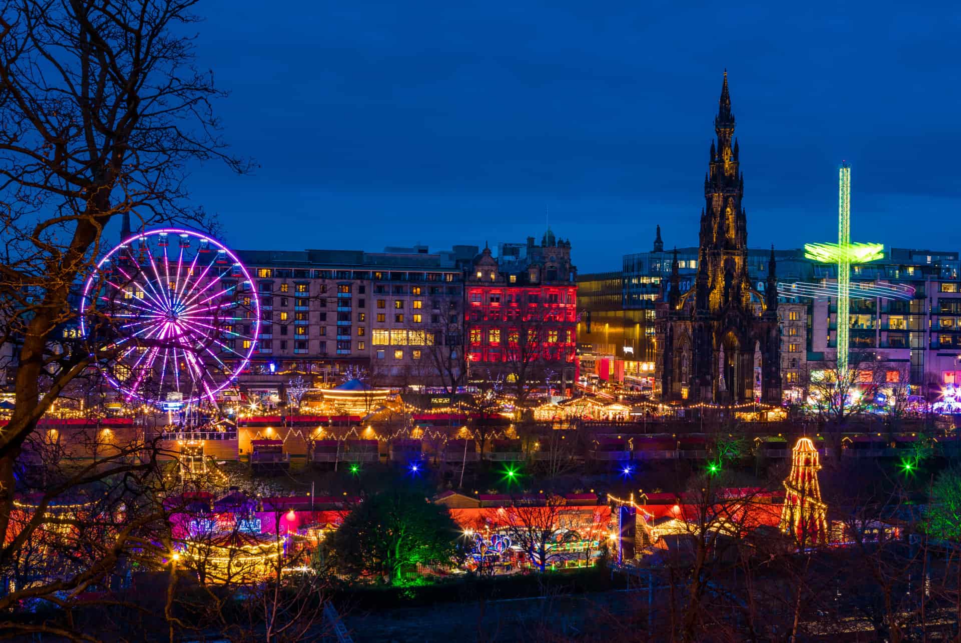 Marché de Noël illuminé de Princes Street Gardens avec la grande roue et le Scott Monument Marché de Noël illuminé de Princes Street Gardens avec la grande roue et le Scott Monument