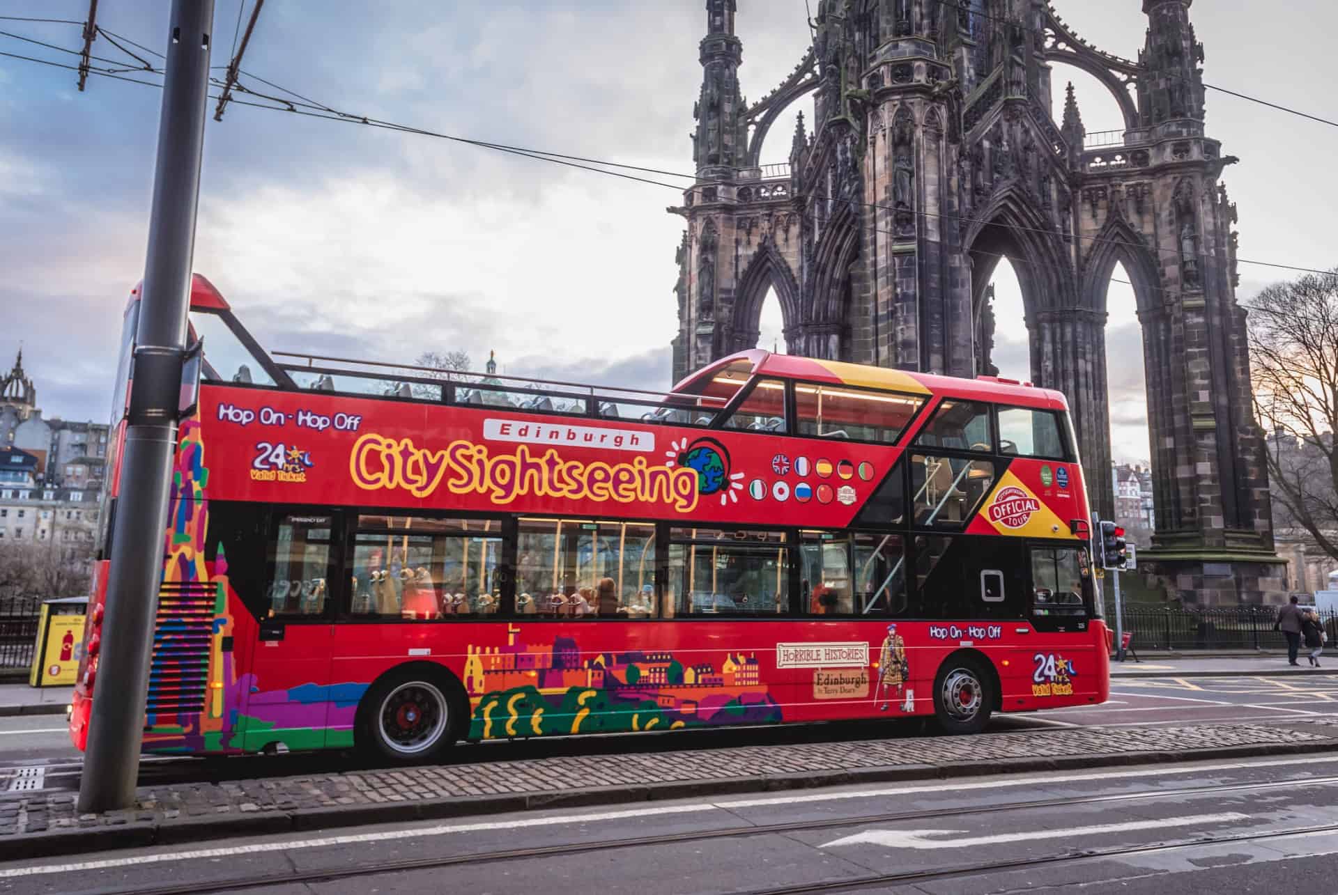 Bus touristique rouge à impériale devant le Scott Monument à Édimbourg Bus touristique rouge à impériale devant le Scott Monument à Édimbourg