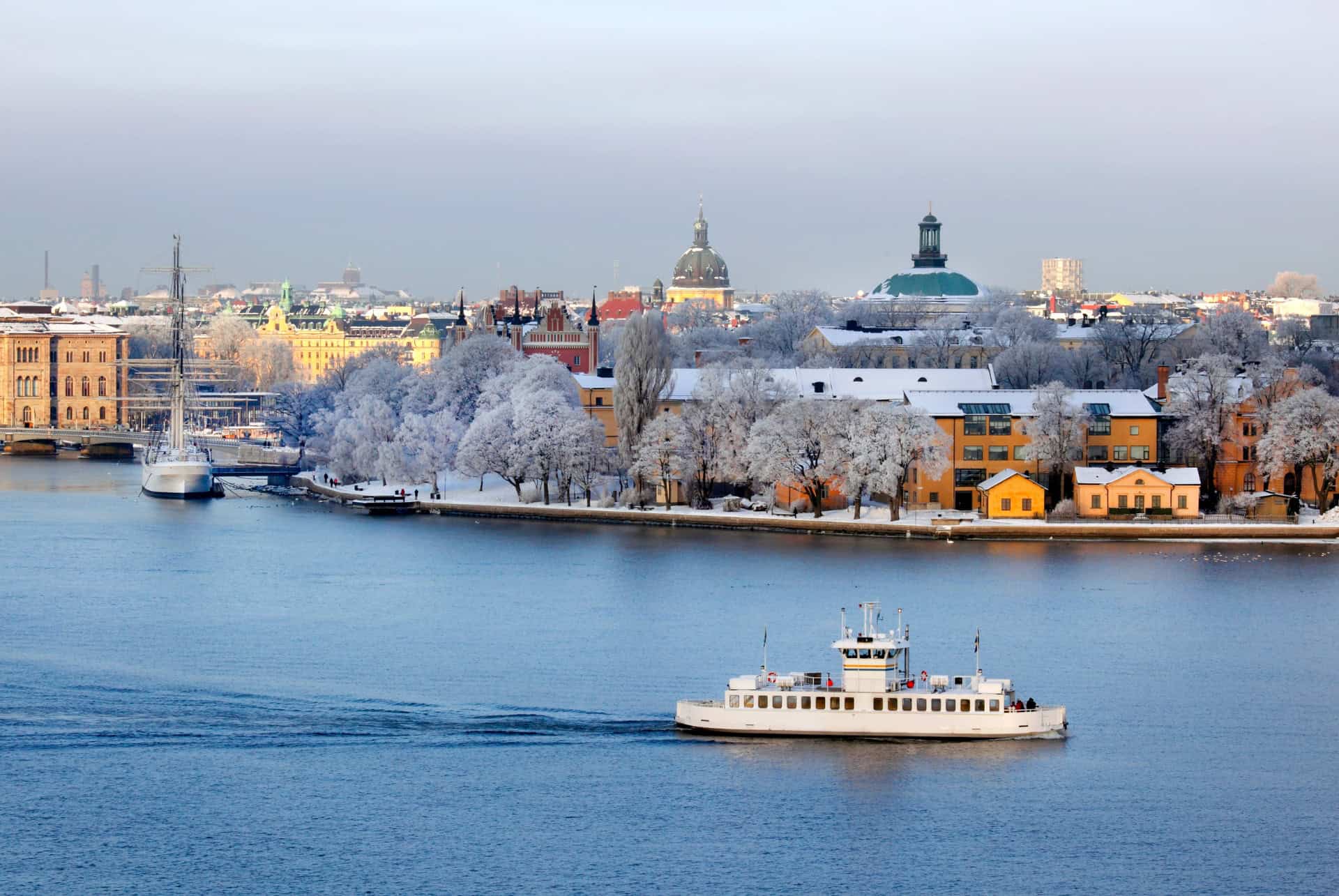 Ferry sur l'eau devant les rives givrées de Stockholm en hiver Ferry sur l'eau devant les rives givrées de Stockholm en hiver