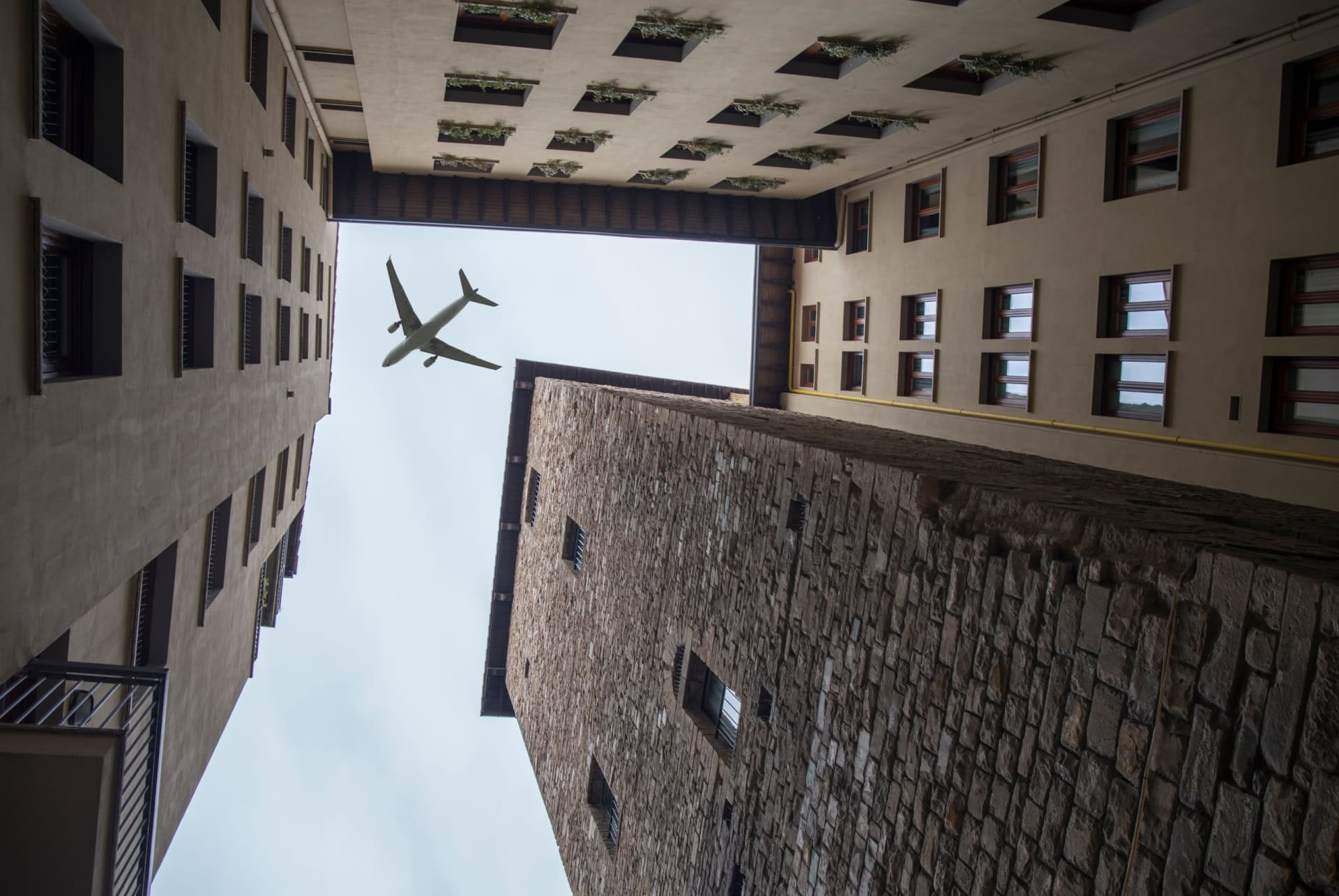 Avion dans le ciel entre les façades d’une rue de Florence Avion dans le ciel entre les façades d’une rue de Florence