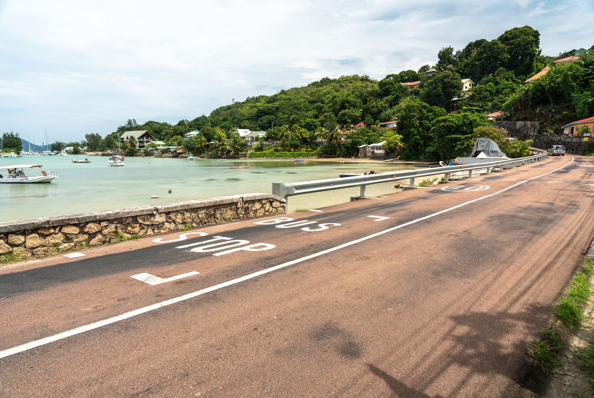 Route côtière de Praslin bordée d’un muret et d’une glissière face à la mer Route côtière de Praslin bordée d’un muret et d’une glissière face à la mer
